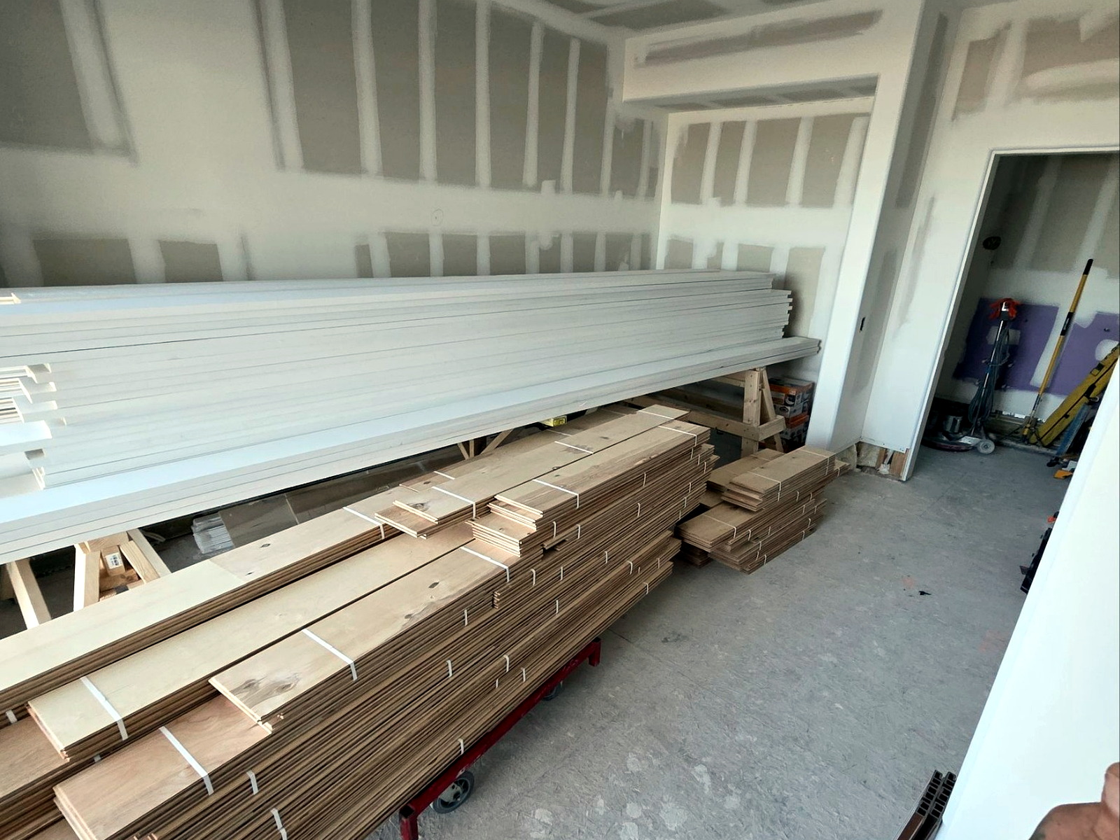 Long lumber and trim materials being unloaded by a final-mile delivery crew