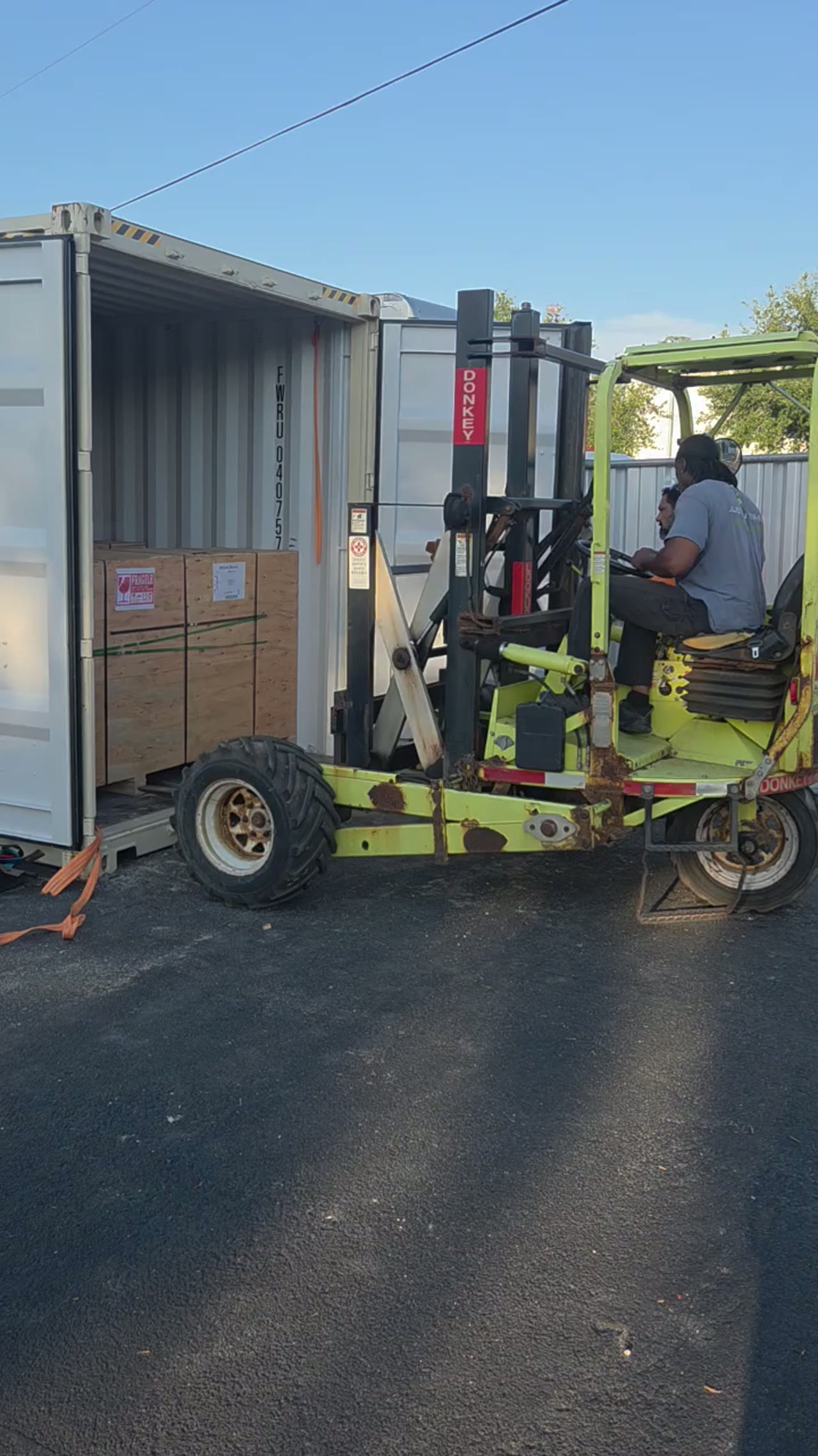 Container Unloading — Tampa Bay — crew devanning a shipping container with a truck-mounted forklift