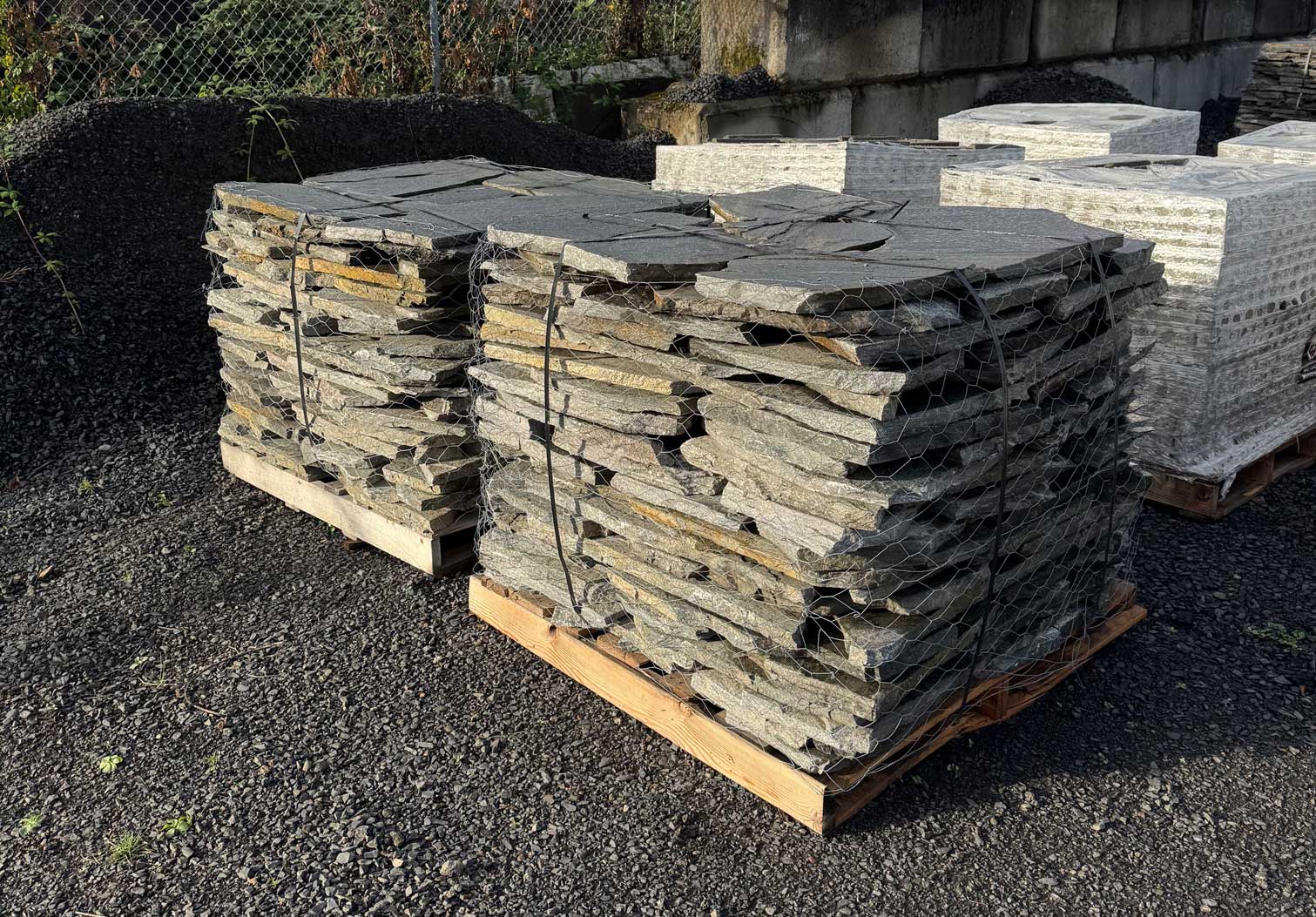 Wire-bound pallets of natural flagstone staged in a stone yard