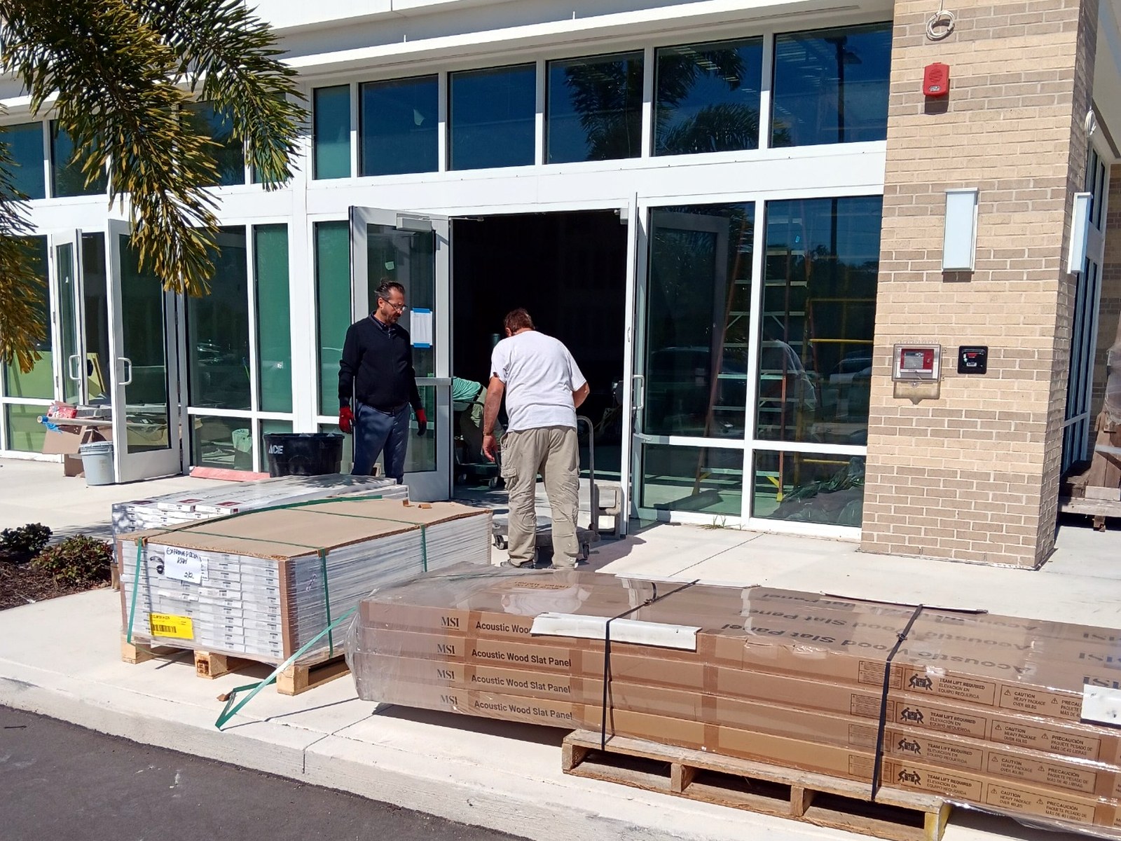 Acoustic wood slat panels and flooring delivered curbside to a commercial jobsite entrance