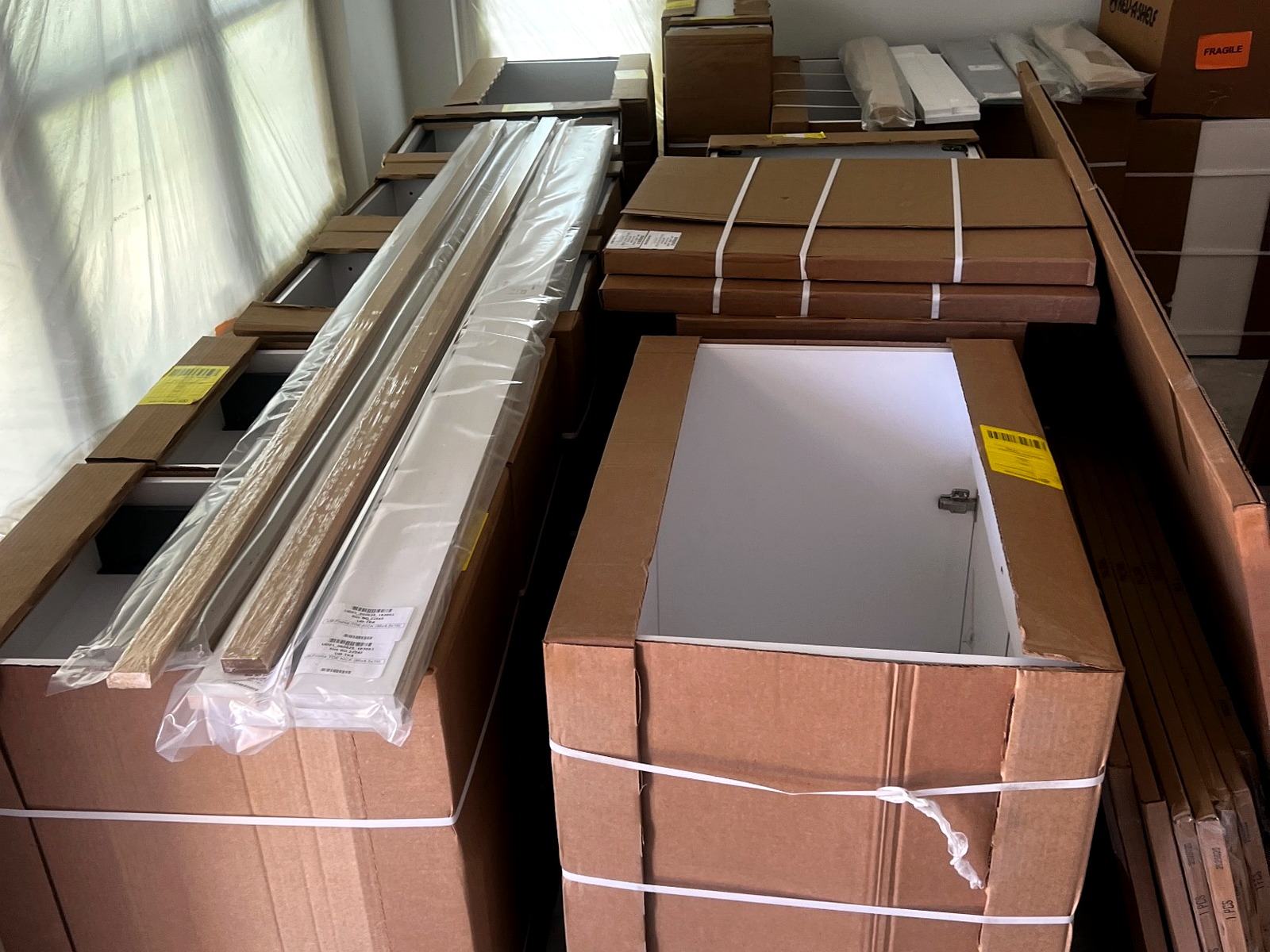 Kitchen cabinet packages staged by room after final-mile delivery