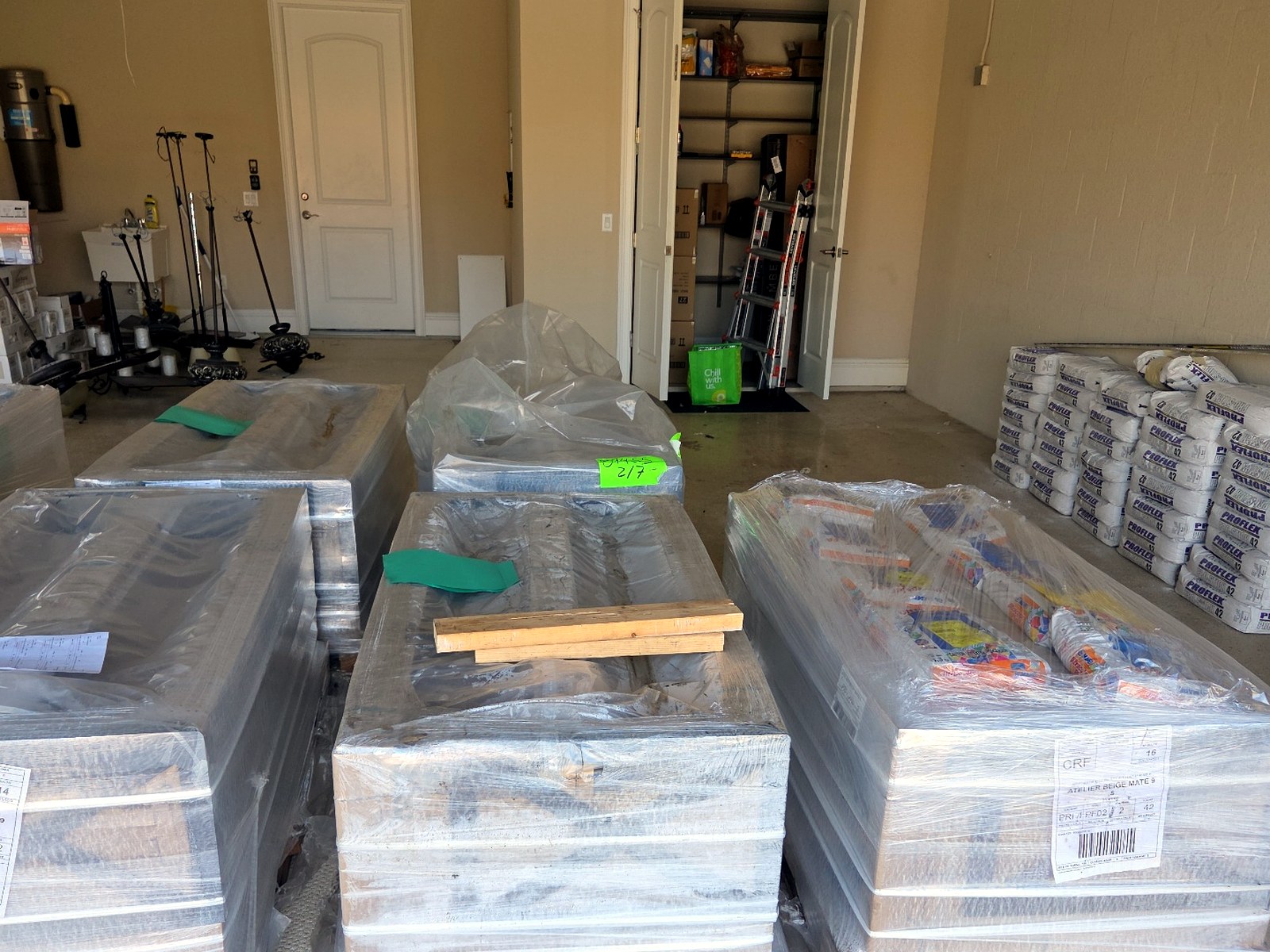 Pallets of tile and stone delivered and staged inside a residential garage by JIT Logistics